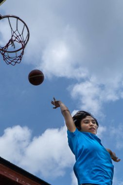 Denpasar, 13 Şubat 23: Endonezya 'nın Bali kentinde bir sokak basketbolu sahasında genç bir atlet smaç bastı.