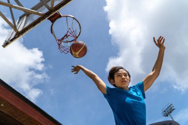Denpasar, 13 Şubat 23: Endonezya 'nın Bali kentinde bir sokak basketbolu sahasında genç bir atlet smaç bastı.