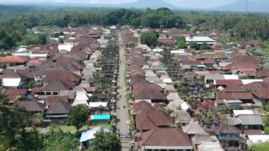 Bali, 01 Ağustos 2023: Bali 'deki Penglipuran köyünün insansız hava aracı görüntüsü geleneksel evler, yemyeşil tepeler, palmiye ağaçları ve açık güneşli havayı gösteriyor