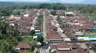 Bali, 01 Ağustos 2023: Bali 'deki Penglipuran köyünün insansız hava aracı görüntüsü geleneksel evler, yemyeşil tepeler, palmiye ağaçları ve açık güneşli havayı gösteriyor