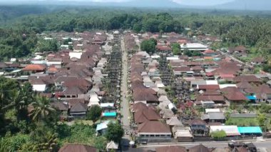 Bali, 01 Ağustos 2023: Bali 'deki Penglipuran köyünün insansız hava aracı görüntüsü geleneksel evler, yemyeşil tepeler, palmiye ağaçları ve açık güneşli havayı gösteriyor