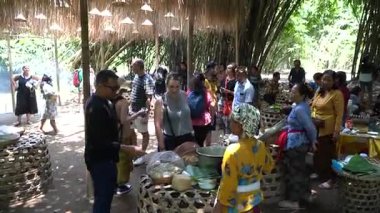 Bali, 15 Ekim 2023: Penglipuran Bangli 'deki canlı geleneksel pazar bambu kulübeleriyle çevrili ve yerli halk otantik Bali yemekleri ve şekerlemeleri satıyor