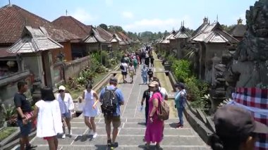Bali, 15 Ekim 2023: Penglipuran Köyü 'nde kiremitli çatıları olan güzel geleneksel evleri turistlerle dolu kalabalık yürüyüş yolu