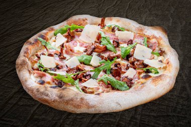 Pastırmalı, reçelli, roka, mozzarella, parmesan soslu pizza. Ahşap arka planda Napolili yuvarlak pizza.