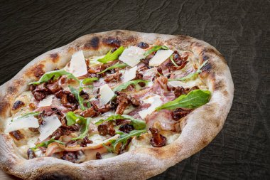 Pastırmalı, reçelli, roka, mozzarella, parmesan soslu pizza. Ahşap arka planda Napolili yuvarlak pizza.