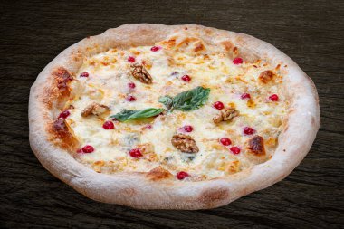 Sülüguni füme peynirli pizza, gorgonzola, mozzarella, dağ külleri, ceviz, bal, fesleğen. Ahşap arka planda Napolili yuvarlak pizza.