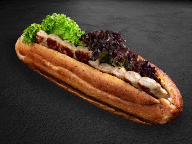 Kızarmış tavuk lula kebabı, marul ve soslu çörek. - Evet. Karanlık bir arka planda izole edilmiş.