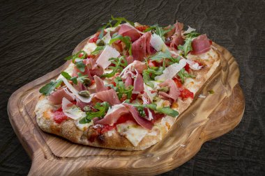 Prosciutto, roka, kapari, pelati soslu Sorrentina pizzası, pesto. Ahşap arka planda Roma pizzası dikdörtgeni
