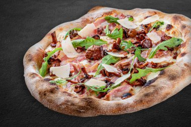 Pastırmalı, reçelli, roka, mozzarella, parmesan soslu pizza. Koyu arkaplanda Napolitan yuvarlak pizza