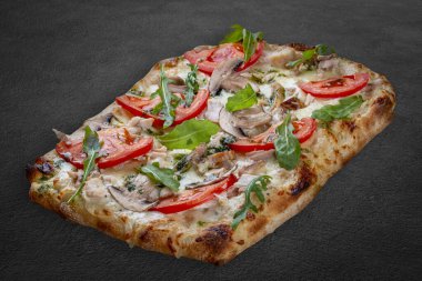 Tütsülenmiş tavuk, roka, peynir sosu, mantar ve pesto soslu bianco pizza. Koyu arkaplanda Roma pizzası dikdörtgeni