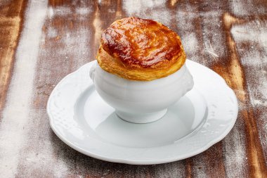 Puf böreğinin altında pişirilmiş yaban mantarı çorbası. Ahşap bir arka planda.