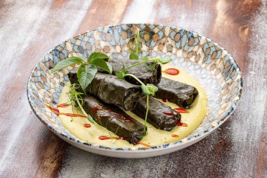Üzüm yapraklı Dolma ve mantarlı jülyen. Mutfağa koşun. Ahşap bir arka planda.