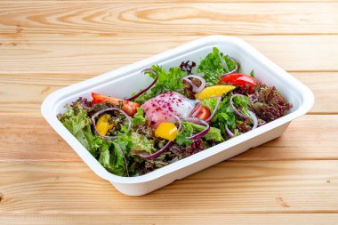 Haşlanmış yumurta ve sebzeli hafif salata. Sağlıklı beslenme. Paket yemek. Çevre ambalajı. Ahşap bir arka planda.