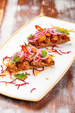 Dana beyinli ve soğanlı çavdar ekmeği. Ahşap bir arka planda.