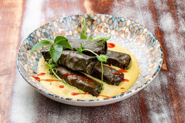 Üzüm yapraklı Dolma ve mantarlı jülyen. Mutfağa koşun. Ahşap bir arka planda.