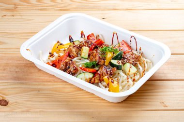 Pişmiş sebzeli biftek ve makarna. Sağlıklı beslenme. Paket yemek. Ekolojik ambalaj. Ahşap bir arka planda.