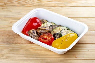 Izgara sebze. Sağlıklı beslenme. Paket yemek. Çevre ambalajı. Ahşap bir arka planda.