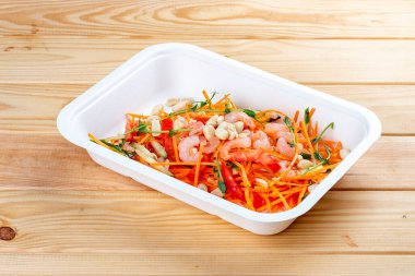 Karides ve doğranmış sebzeli salata. Sağlıklı beslenme. Paket yemek. Ekolojik ambalaj. Ahşap bir arka planda.