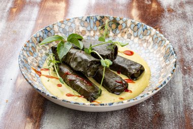 Üzüm yapraklı Dolma ve mantarlı jülyen. Mutfağa koşun. Ahşap bir arka planda.