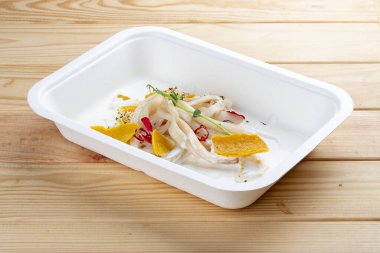 Dukan 'a göre yoğurtta kalamar varmış. Sağlıklı beslenme. Paket yemek. Çevre ambalajı. Ahşap bir arka planda.