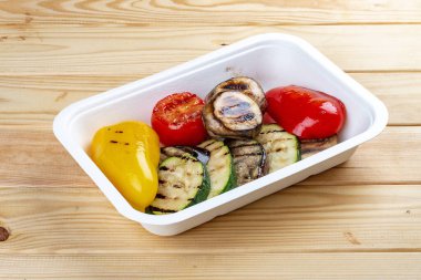 Izgara sebze. Sağlıklı beslenme. Paket yemek. Çevre ambalajı. Ahşap bir arka planda.