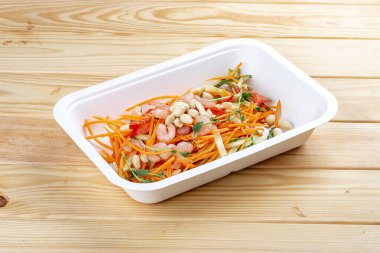 Karides ve doğranmış sebzeli salata. Sağlıklı beslenme. Paket yemek. Ekolojik ambalaj. Ahşap bir arka planda.