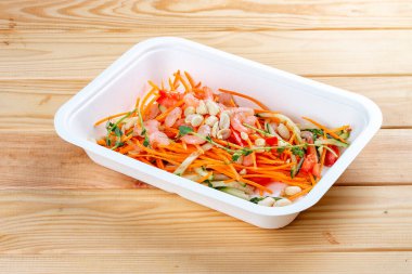 Karides ve doğranmış sebzeli salata. Sağlıklı beslenme. Paket yemek. Ekolojik ambalaj. Ahşap bir arka planda.