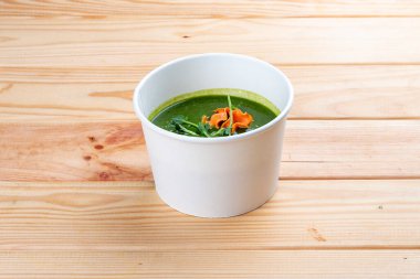 Broccoli puree soup. Healthy diet. Takeaway food. Ecological packaging. On a wooden background. clipart