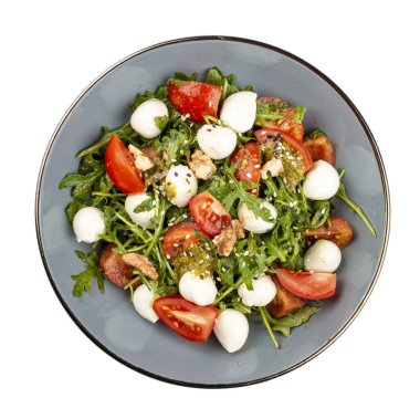 Caprese salatası, kiraz domatesleri, mozzarella, roka ve pesto sosu. İzole edilmiş resim