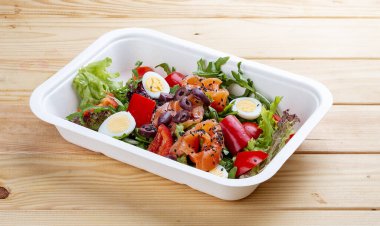 Hafif tuzlu somon ve dolmalık biberli salata. Sağlıklı yiyecekler. Paket yemek. Ahşap bir arka planda.