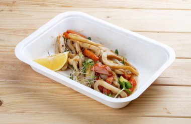 Kalamar makarnası. Sağlıklı yiyecekler. Paket yemek. Ahşap bir arka planda.