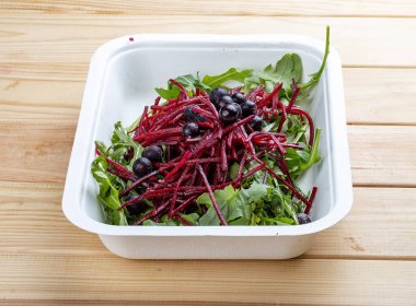Roka salatası, pancar ve böğürtlen. Sağlıklı yiyecekler. Paket yemek. Ahşap bir arka planda.