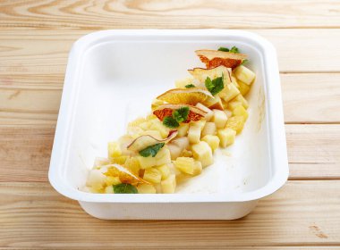 Nane aromalı meyve salatası. Sağlıklı beslenme. Paket yemek. Ahşap bir arka planda.