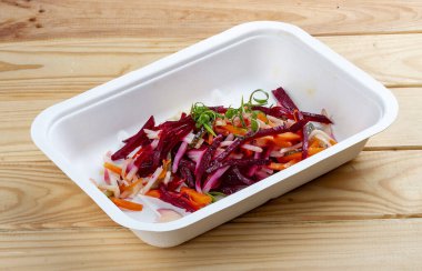 Vinigret salatası. Vejetaryen yemeği. Paket yemek. Ahşap bir arka planda.