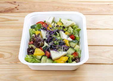 Camembert peynirli Fransız salatası. Sağlıklı yiyecekler. Paket yemek. Ahşap bir arka planda.