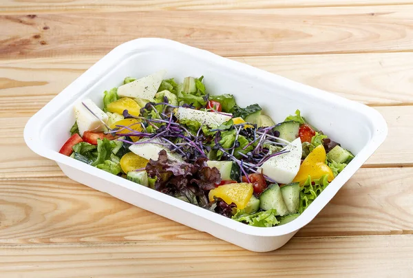 Camembert peynirli Fransız salatası. Sağlıklı yiyecekler. Paket yemek. Ahşap bir arka planda.