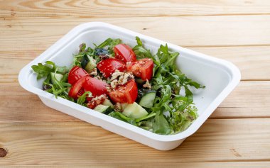 Cevizli sebze salatası. Sağlıklı yiyecekler. Paket yemek. Ahşap bir arka planda.