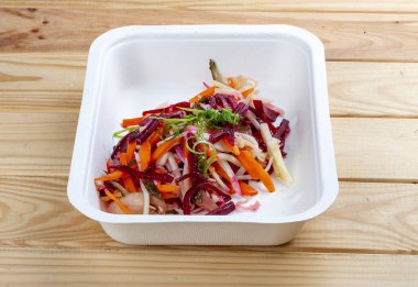 Vinigret salatası. Vejetaryen yemeği. Paket yemek. Ahşap bir arka planda.