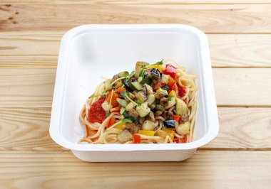 Sebzeli ortolana makarnası. Sağlıklı yiyecekler. Paket yemek. Ahşap bir arka planda.