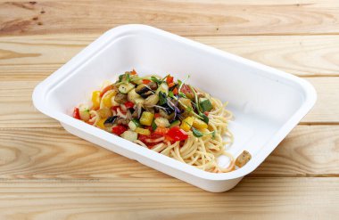 Sebzeli ortolana makarnası. Sağlıklı yiyecekler. Paket yemek. Ahşap bir arka planda.