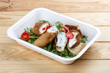 Ricotta peynirli ve ıspanaklı kaneloni. Paket yemek. Ahşap bir arka planda.