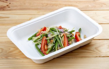 Tayland sebze salatası. Vejetaryen yemeği. Paket yemek. Üst görünüm, gri arkaplanda.