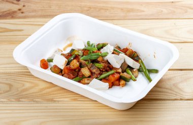 Pişmiş sebzeler. Sağlıklı beslenme. Paket yemek. Ekolojik ambalaj. Ahşap bir arka planda.