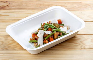 Pişmiş sebzeler. Sağlıklı beslenme. Paket yemek. Ekolojik ambalaj. Ahşap bir arka planda.