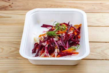 Vinigret salatası. Vejetaryen yemeği. Paket yemek. Ahşap bir arka planda.