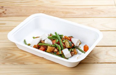 Haşlanmış sebze. Sağlıklı yiyecekler. Paket yemek. Çevre dostu ambalaj. Ahşap bir arka planda.