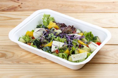 Camembert peynirli Fransız salatası. Sağlıklı yiyecekler. Paket yemek. Ahşap bir arka planda.