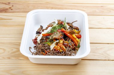 Sebzeli karabuğday eriştesi. Vejetaryen yemeği. Paket yemek. Ahşap bir arka planda.