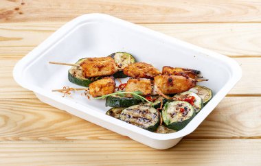 Kabaklı ızgara tavuk kebabı. Sağlıklı beslenme. Paket yemek. Ahşap bir arka planda.