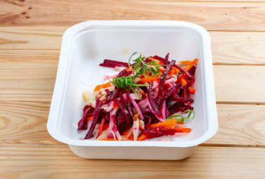 Vinigret salatası. Vejetaryen yemeği. Paket yemek. Ahşap bir arka planda.